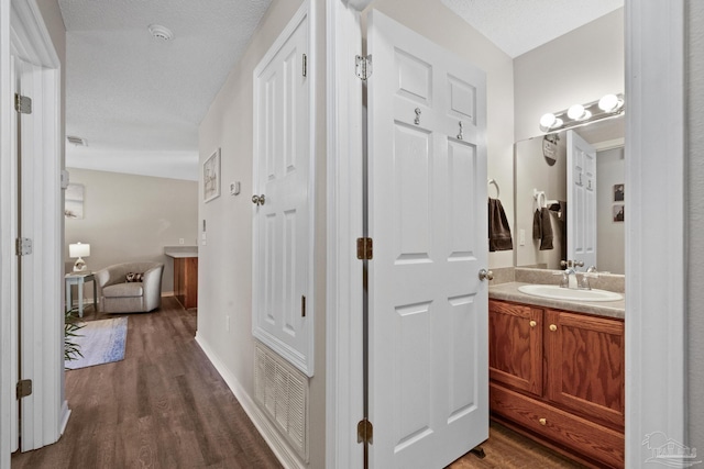 bathroom with vanity, a textured ceiling, and hardwood / wood-style flooring