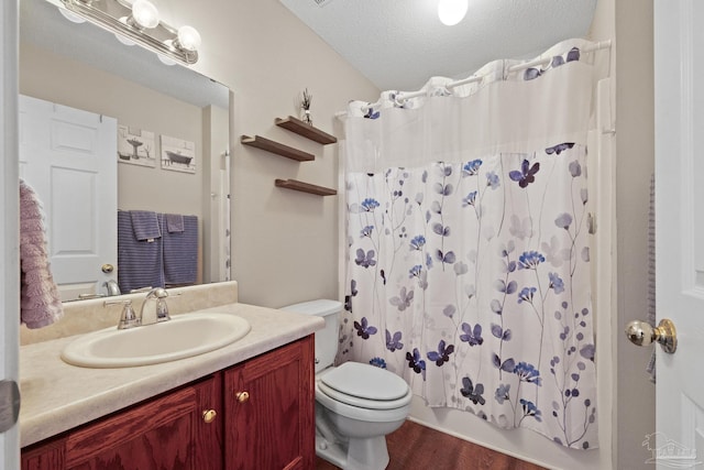 full bathroom with wood-type flooring, a textured ceiling, toilet, shower / tub combo with curtain, and vanity