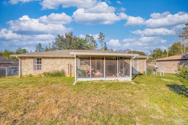 rear view of property with a sunroom and a yard