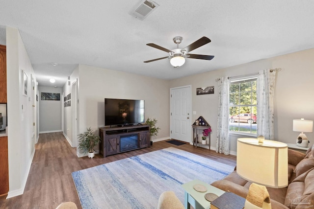 living room featuring hardwood / wood-style floors, a textured ceiling, and ceiling fan