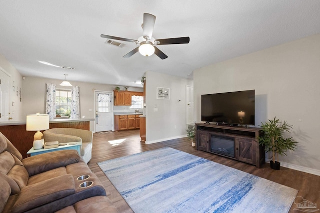 living room featuring dark hardwood / wood-style flooring and ceiling fan