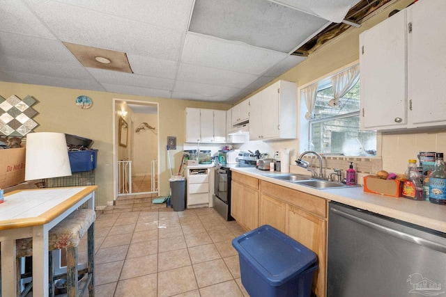 kitchen featuring white cabinets, light tile patterned floors, appliances with stainless steel finishes, a drop ceiling, and sink