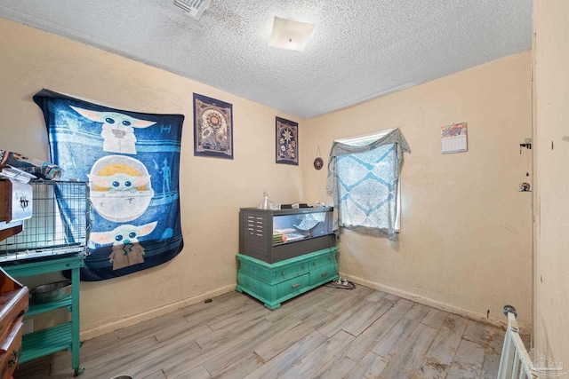 misc room featuring light hardwood / wood-style floors and a textured ceiling