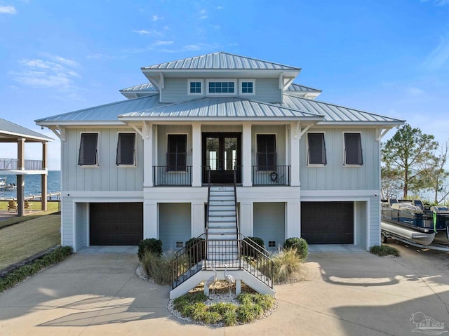 view of front facade with board and batten siding, concrete driveway, stairway, and an attached garage