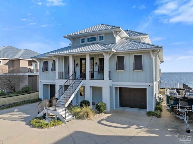 view of front of property with covered porch, an attached garage, board and batten siding, driveway, and stairs