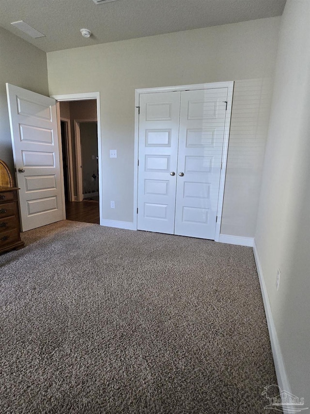 unfurnished bedroom featuring a closet, carpet flooring, and baseboards