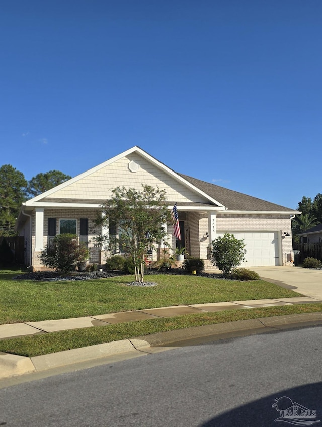 view of front of property with a front yard, brick siding, a garage, and driveway