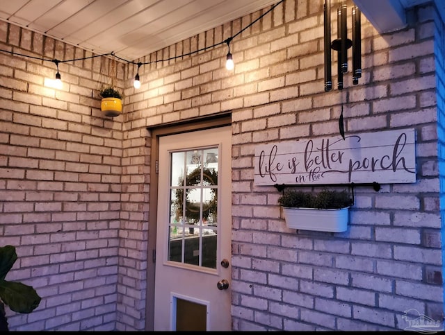 entrance to property featuring brick siding