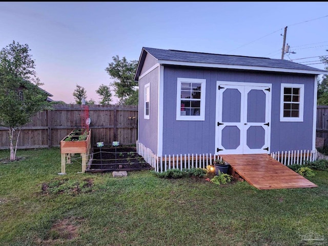 view of shed with a vegetable garden and a fenced backyard