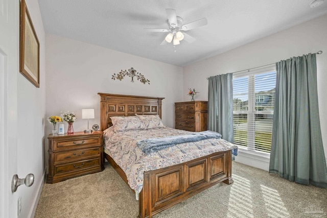 bedroom with baseboards, a ceiling fan, and light colored carpet