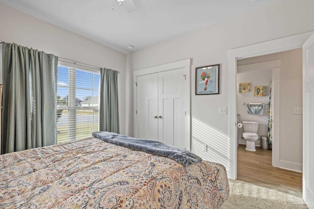 bedroom featuring a closet, wood finished floors, a ceiling fan, and baseboards