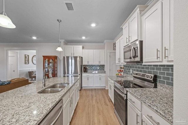 kitchen featuring stainless steel appliances, light wood-type flooring, white cabinets, and a sink