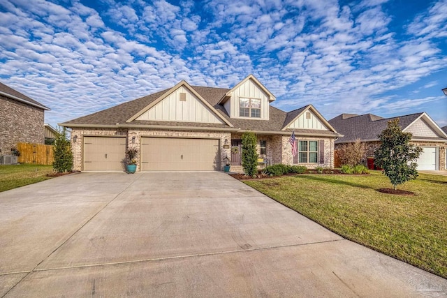 view of front of house featuring a garage, concrete driveway, fence, a front yard, and brick siding