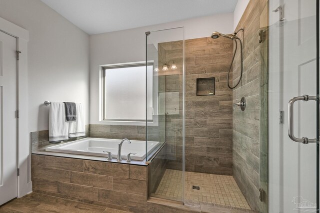 bathroom with a garden tub and a shower stall