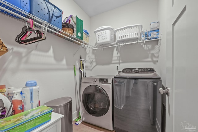 clothes washing area with laundry area, independent washer and dryer, and light wood finished floors