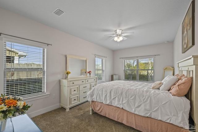 bedroom with a ceiling fan, visible vents, dark carpet, and baseboards