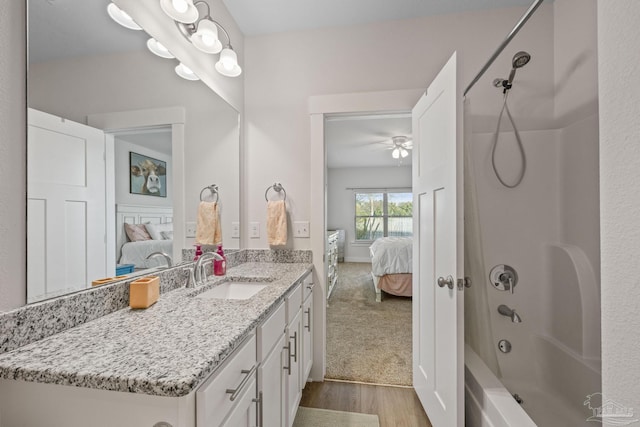 ensuite bathroom with wood finished floors, tub / shower combination, connected bathroom, and vanity