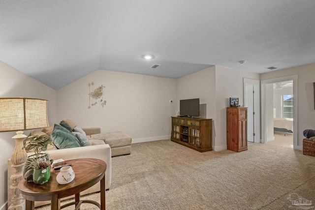 carpeted living room with lofted ceiling, visible vents, and baseboards