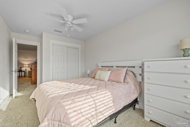 carpeted bedroom featuring a closet, visible vents, and a ceiling fan