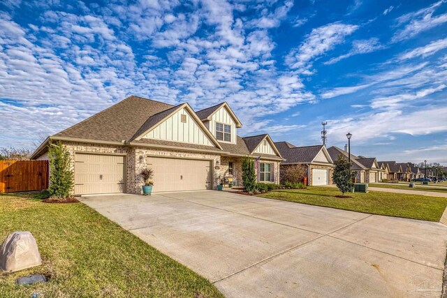 view of front of house featuring an attached garage, board and batten siding, a front yard, fence, and driveway