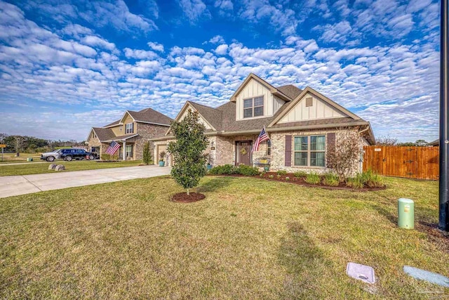 craftsman house featuring brick siding, an attached garage, board and batten siding, fence, and driveway