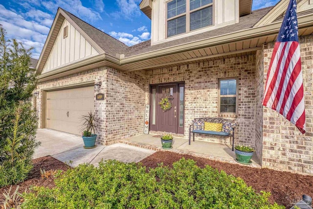 view of exterior entry featuring a porch, a garage, brick siding, driveway, and board and batten siding