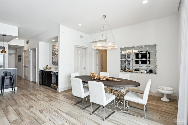 dining space featuring wine cooler and light wood-type flooring