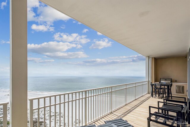 balcony featuring a water view and a beach view