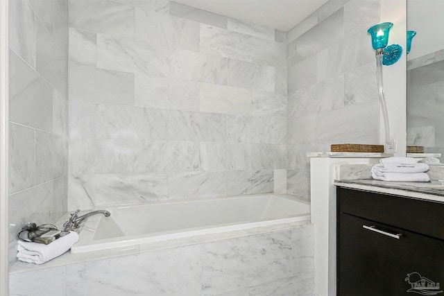 bathroom with vanity, tiled bath, and tile walls