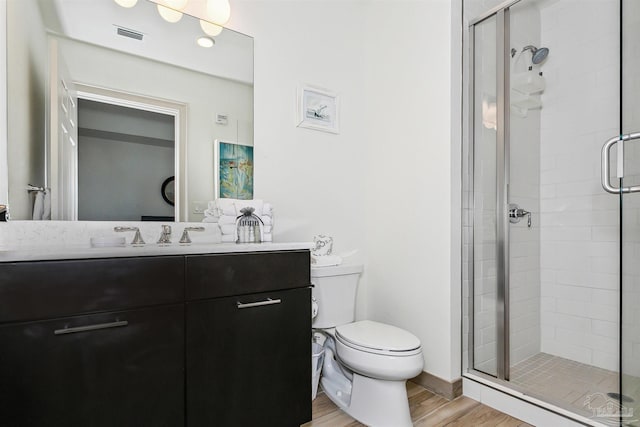 bathroom with a shower with door, wood-type flooring, vanity, and toilet