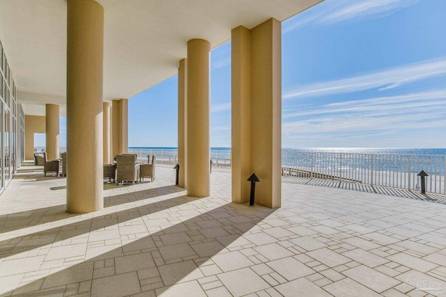 view of patio featuring a water view and a beach view