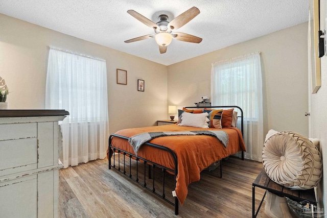 bedroom featuring multiple windows, ceiling fan, and light wood-type flooring