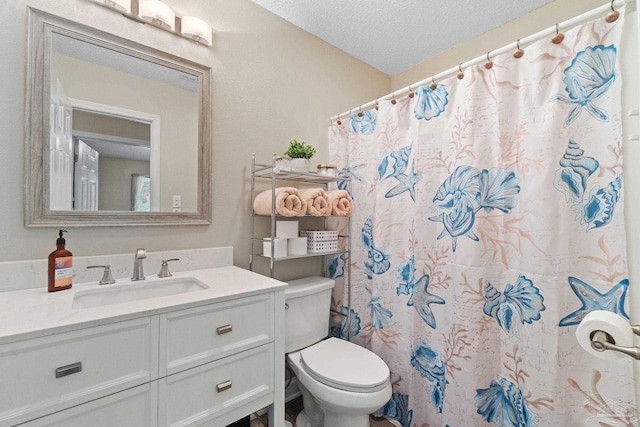 bathroom featuring walk in shower, vanity, toilet, and a textured ceiling