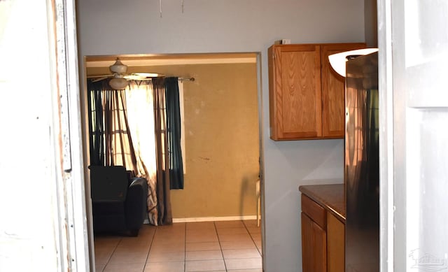 clothes washing area with ceiling fan and light tile patterned floors