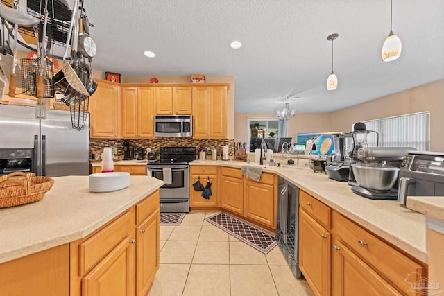 10108 Castleberry Blvd, Pensacola, FL 32526 - kitchen with appliances with stainless steel finishes, light countertops, tasteful backsplash, pendant lighting, and beverage cooler