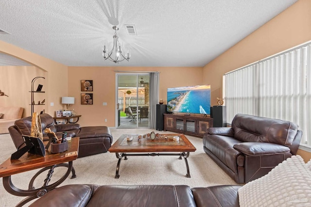 10108 Castleberry Blvd, Pensacola, FL 32526 - living room featuring a chandelier, carpet flooring, a textured ceiling, and arched walkways