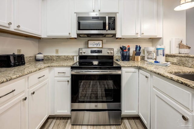 kitchen featuring light hardwood / wood-style floors, white cabinetry, and appliances with stainless steel finishes