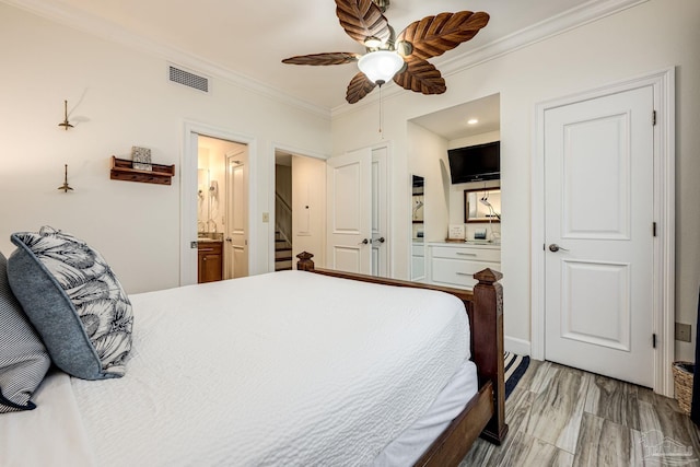 bedroom with ceiling fan, crown molding, and ensuite bath