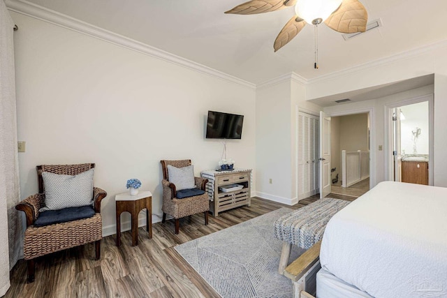 bedroom featuring dark hardwood / wood-style floors, ceiling fan, ensuite bathroom, and crown molding