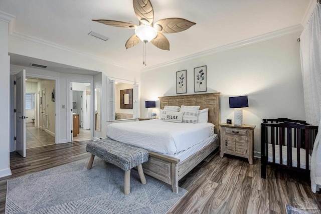 bedroom featuring hardwood / wood-style floors, ceiling fan, crown molding, and ensuite bath