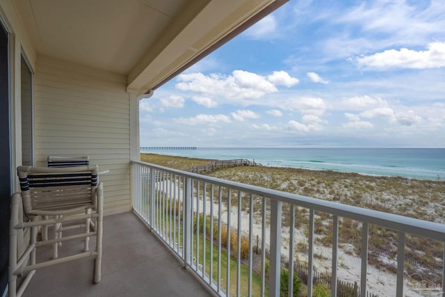 balcony featuring a water view and a view of the beach