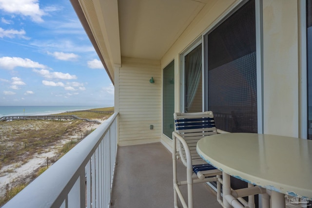 balcony featuring a water view and a beach view