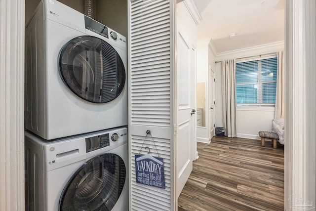 laundry area with stacked washer / dryer, dark hardwood / wood-style floors, and ornamental molding