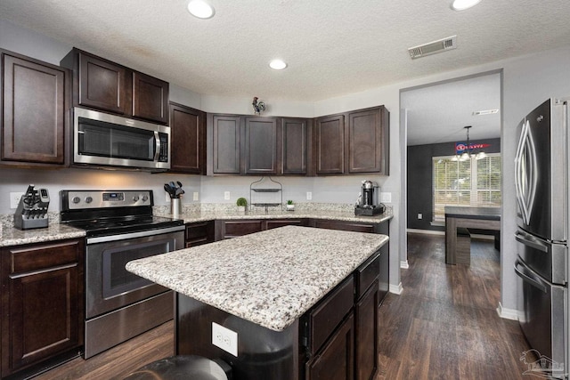 kitchen with dark brown cabinets, a textured ceiling, stainless steel appliances, dark wood-type flooring, and a center island