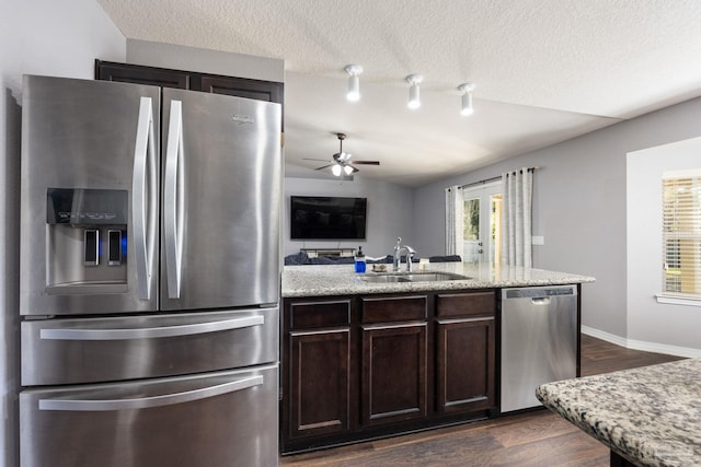 kitchen featuring appliances with stainless steel finishes, a textured ceiling, ceiling fan, sink, and dark hardwood / wood-style floors