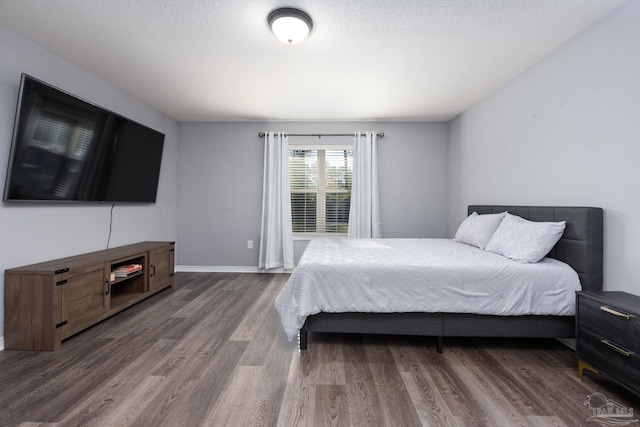 bedroom with a textured ceiling and hardwood / wood-style flooring