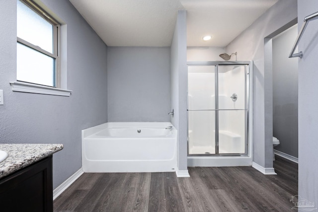 full bathroom with wood-type flooring, vanity, toilet, and independent shower and bath