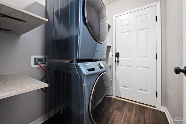 washroom featuring dark hardwood / wood-style flooring and stacked washing maching and dryer