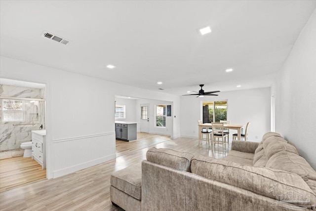 living room featuring ceiling fan and light wood-type flooring