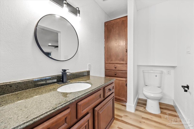 bathroom with vanity, hardwood / wood-style floors, and toilet